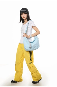 Close-up of light blue checkered hobo bag with fringe detail on casual model outfit