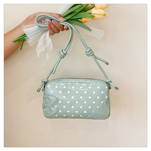 Detail of mint green polka dot handbag with 3D number emblem and matching shoulder strap