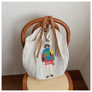Detailed knit of white crochet tote bag featuring colorful girl embroidery and brown leather handles