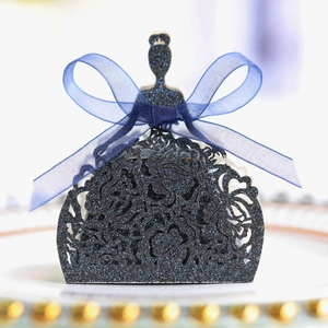 Détail d'une boîte à bonbons pailletée bleue avec motif robe de princesse évidée