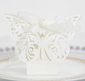 Close-up of white laser-cut hollow butterfly gift box with elegant organza ribbon