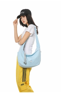 Hobo style light blue canvas crossbody bag with adjustable wide strap on casual model