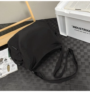 Détail du sac bandoulière en nylon noir avec étiquette CHUANGMI et sangle réglable