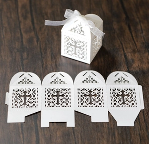 White laser-cut cross wedding favor box with ribbon and unassembled flat template