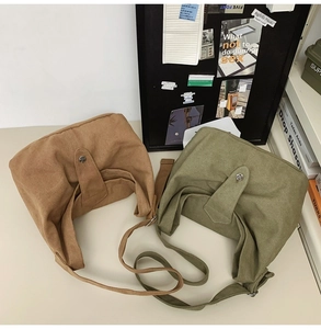 Top view of canvas tote bags in brown and sage green with adjustable straps and metal buckles