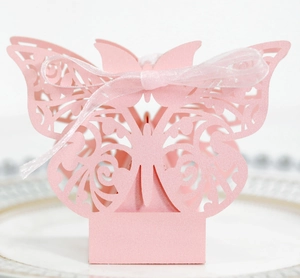 Detail of pink laser-cut butterfly wedding favor box with a soft sheer ribbon
