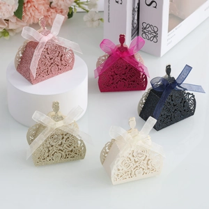 Détails des motifs de roses découpés au laser sur d'élégantes boîtes à dragées à paillettes