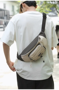 Outdoor close-up of a two-tone nylon crossbody bag showing the adjustable buckle strap