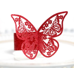 Detalle del servilletero de mariposa roja con purpurina y textura de corte láser