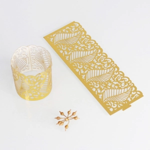 Detailed view of golden laser-cut hollow tea light candle wraps with elegant leaf pattern