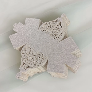 Flat lay of silver glitter gift boxes with laser-cut hollow floral design and girl pattern