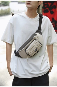 Detailed close-up of the stylish beige and dark gray crossbody chest bag on a model
