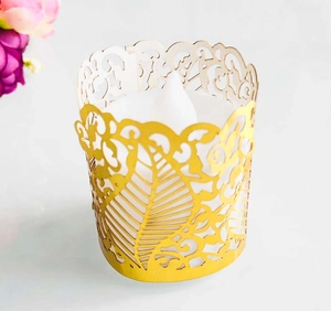 Close-up of golden laser-cut paper candle wrap with intricate floral hollow pattern