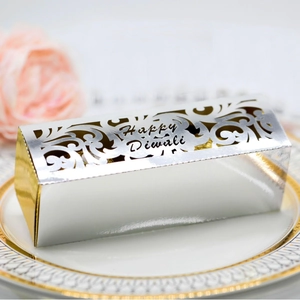 Golden laser-cut Happy Diwali hollow gift box on elegant plate with decorative roses