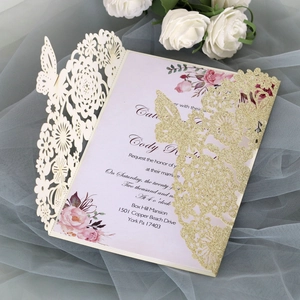 Detailed laser-cut glitter butterfly and cream floral pattern on a wedding invitation set
