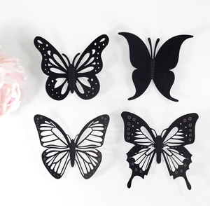 Détail de quatre papillons 3D noirs avec divers motifs ajourés pour décoration