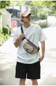 Outdoor shot of a beige and dark grey nylon crossbody chest bag with multiple pockets