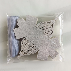 Flat lay of unassembled hollow floral glitter cardstock and organza ribbon in packaging