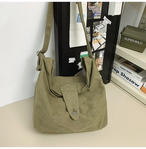 Detail of moss green canvas hobo bag with vintage buckle and wide shoulder strap