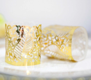 Close-up of golden laser-cut hollow decorative wrap with elegant leaf and wave patterns