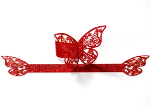 Detalle del servilletero de mariposa con purpurina roja y textura cortada con láser