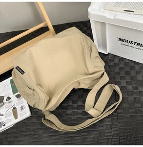 Détail du sac fourre-tout kaki en nylon avec large bandoulière et étiquette de marque