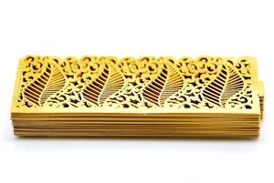 Close-up of golden hollowed-out paper candle shades with intricate laser-cut vine patterns