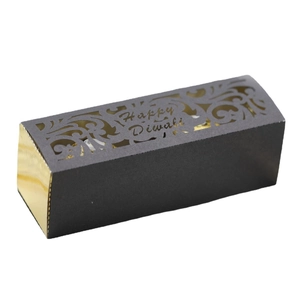 Golden and black Diwali favor box with laser-cut floral patterns and Happy Diwali text