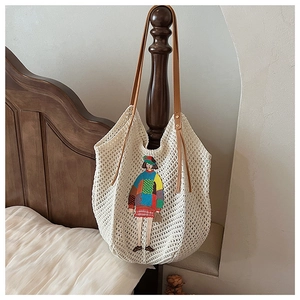 Detail of beige crochet tote bag with colorful embroidery and brown leather tassel strap