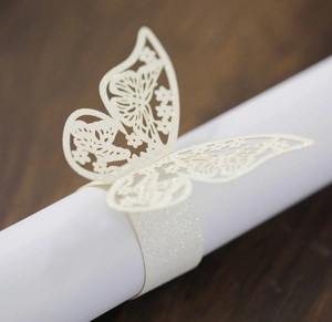 Primer plano del servilletero mariposa de purpurina crema con detalles cortados por láser