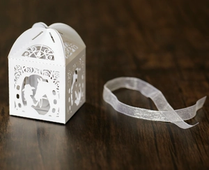 Detail einer lasergeschnittenen Hochzeitsbox mit Pferdesilhouette und weißem Band
