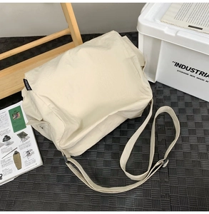 Détail du sac cabas en nylon blanc cassé avec texture plissée et bandoulière réglable