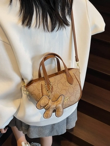 Schicke braune Handtasche mit Monogramm, verstellbarem Gurt und süßem Hundeanhänger