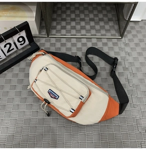 Detail of crossbody chest bag featuring orange elastic cords and quick-release buckle