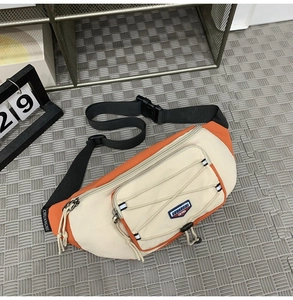 Detail of orange and beige crossbody bag with adjustable strap and bungee cords