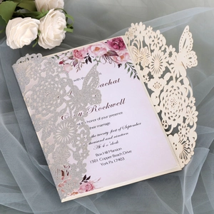 Detail of silver glitter laser-cut wedding invitation with butterfly and floral patterns
