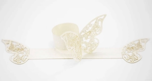 Detalle de servilletero de mariposa calada con corte láser en papel perlado crema