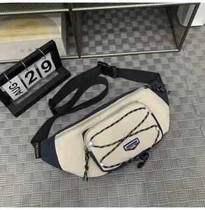 Detail of crossbody chest bag with contrast cream and navy colors and bungee cord mesh