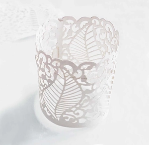 Close-up of white laser-cut paper candle wraps featuring intricate floral vein patterns