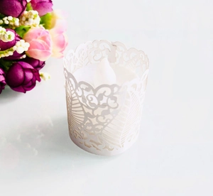 Intricate laser-cut white floral tea light sleeve with glowing LED candle decor