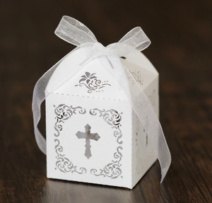 Détail de la boîte à bonbons blanche découpée au laser avec motif croix et ruban