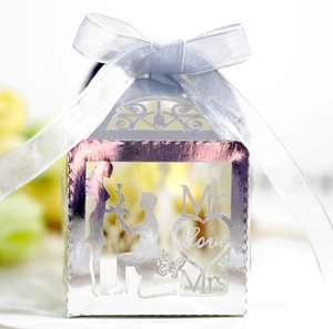 Detail of silver laser-cut wedding favor box with Mr & Mrs text and satin ribbon