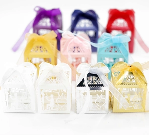 Macro view of assorted laser-cut wedding favor boxes with Mr & Mrs ribbon details