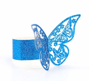 Detalle macro del servilletero de mariposa cortado con láser y purpurina azul