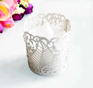 Close-up of laser-cut white pearl paper lace wrap for LED tea light candles and cupcakes