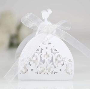 Macro shot of white laser-cut butterfly wedding favor box with organza ribbon bow
