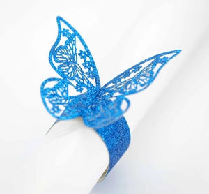 Detalle de servilletero de mariposa con purpurina azul y diseño calado por láser