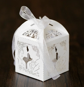 Detalle de caja de regalo para boda color marfil cortada con láser y lazo decorativo