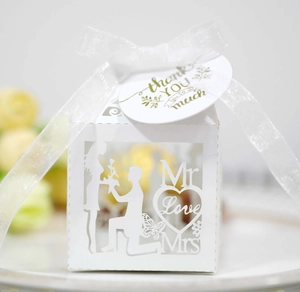 Detail of white laser-cut wedding favor box with Mr & Mrs silhouette and thank you tag