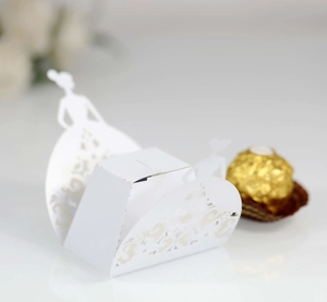 Macro detail of laser-cut butterfly candy box with bride silhouette and lace patterns